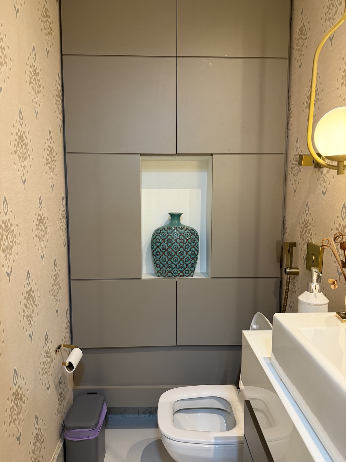 Lavabo do novo consultório, com vaso decorativo turquesa e detalhes dourados